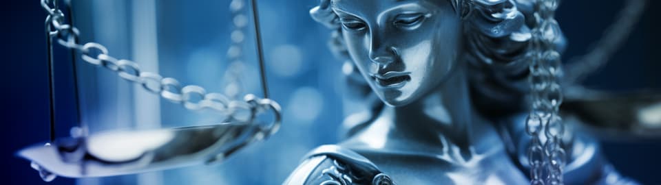 Kursübersicht Compliance Metallstatue von Justitia vor blauem Hintergrund